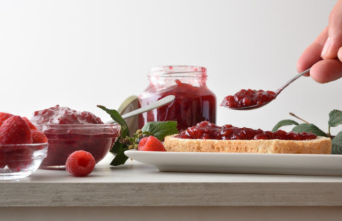jam being added to bread from a pot not given to dog