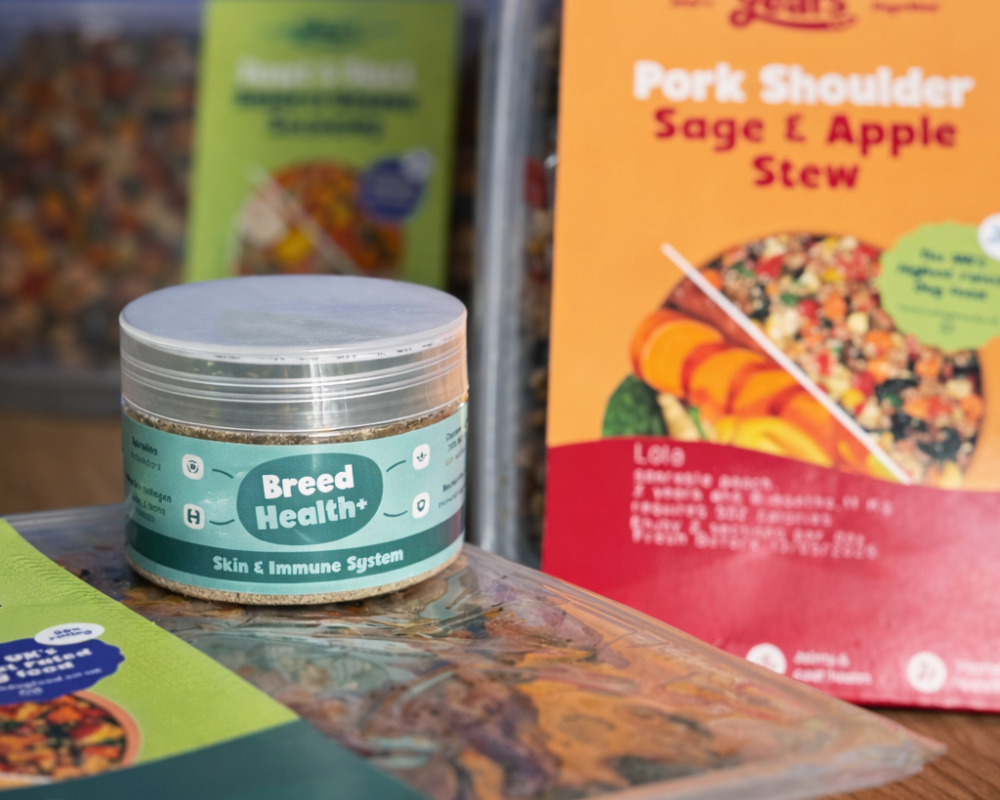 Jar labeled 'Breed Health+' with pet food packages in the background
