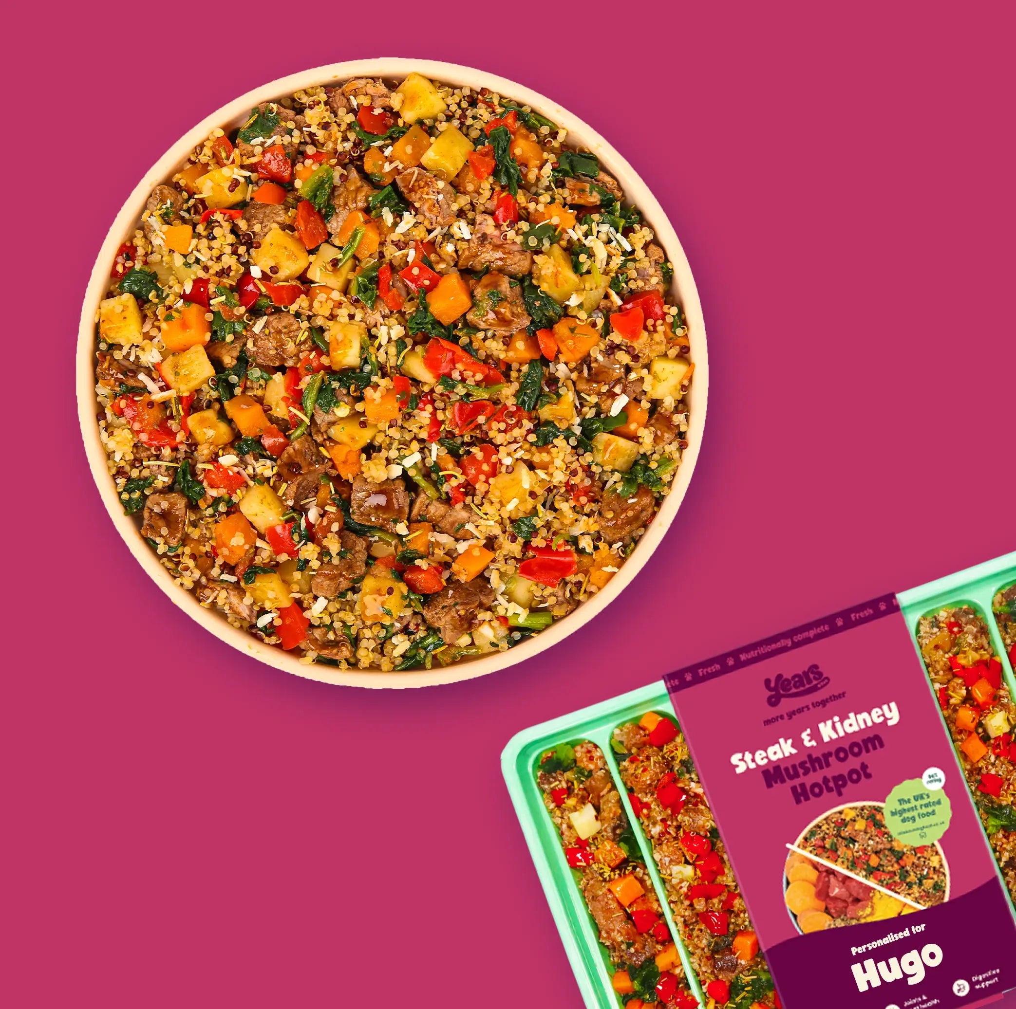 A vibrant magenta background with a round bowl on the left filled with a colorful mix of diced steak, kidney, mushrooms, quinoa, red pepper, carrot, potato and greens. On the right is a green three-compartment meal tray partially covered by a matching magenta sleeve labeled “Years – Steak & Kidney Mushroom Hotpot, personalised for Hugo,” showing the same chunky hotpot portions.
